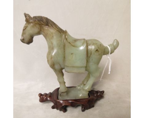 A Chinese jade sculpture of a Tang dynasty horse with dark brown to black coloured markings, on carved wooden stand, 5 2/3 hi