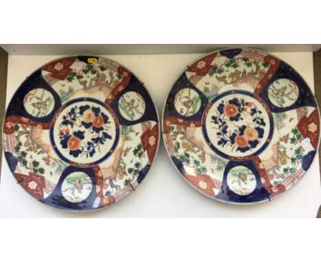 A pair of 19th Century Japanese Imari chargers of typical form with panel decoration of garden settings, flowers etc, unsigne