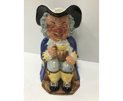 A Clarice Cliff Wilkinsons Ltd Toby jug as "Gentleman in tri-corn and blue long coat seated with an overflowing beer upon his