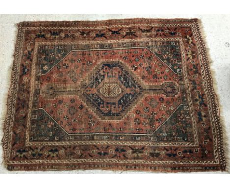 A Caucasian rug, the central panel set with lozenge medallion on a red and green ground, with stylised flower head decoration