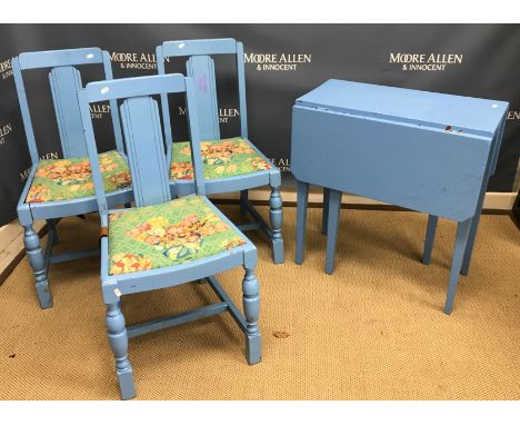 A blue painted drop-leaf kitchen table, three blue painted chairs, two blue stained rush seat ladder back kitchen chairs and 