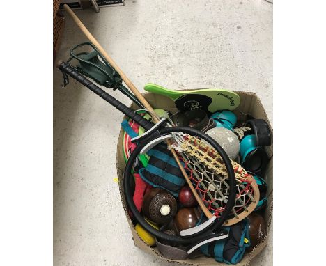 A box of various sporting items including beach ball bats, quoits, ear muffs, shooting stick, hockey stick, cricket balls, we