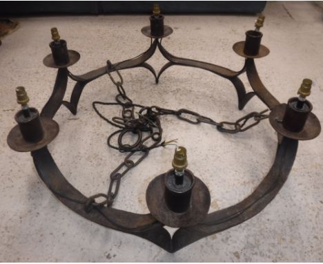 A 20th Century wrought iron eight light electrolier in the Arts &amp; Crafts manner, the candle holder type lights with drip 