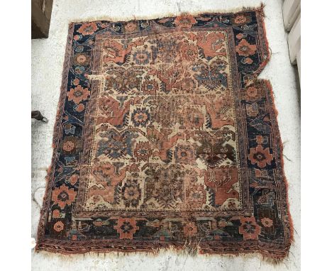 A Persian rug, the central panel set with repeating stylised bird and floral motifs on a cream ground, within a stepped blue 