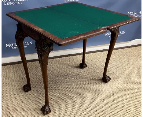 A 1920s burr walnut veneered fold-over card table in the Georgian style, the top with foliate carved edge opening to reveal a