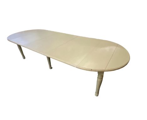 A light green painted extending dining table, inset with leaves, as found (folding right up to a narrow side table with two f