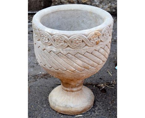 A composite stone circular planter decorated with Aztec design on circular base