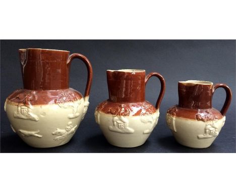 Three graduating stoneware two tone jugs with stag hunting and toping scenes in relief, and one other