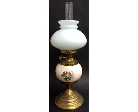 A brass oil lamp with ceramic reservoir depicting hunting scenes, with glass and shade