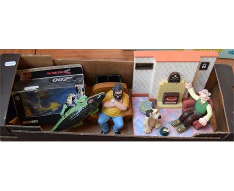 A box of toys, including a Wallace & Gromit radio alarm clock, speaking Jim Royle character in armchair, animated tin toy cro