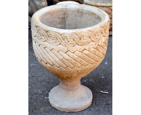 A composite stone circular planter decorated with Aztec designs on circular base