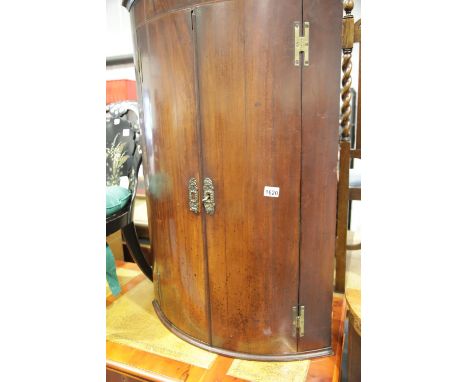 Georgian mahogany bow front enclosed corner cupboard with fitted interior of shelves and drawers, H: 108 cm.  This lot is not