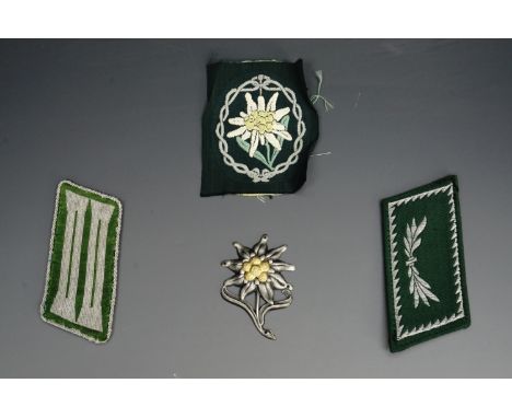 A German army mountain troops / gebirgsjager BeVo machine woven arm badge together with an edelweiss cap badge and other insi