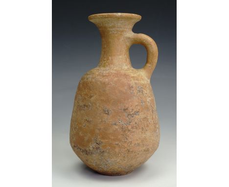 An ancient Roman redware / red slip earthenware flagon, having a tapering body, slender neck with everted rim, and ribbed loo