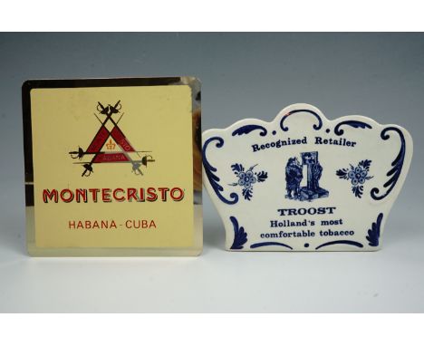 A vintage Troost blue and white ceramic advertising plaque together with another aluminium plaque 