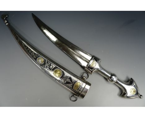 A Middle Eastern khanjar / dagger gifted by Saddam Hussein, the handle and scabbard in niello and white metal, 44 cm overall.