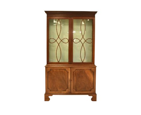 A George III mahogany bookcase cabinetThe dentil cornice above a blind fretwork frieze and twin astragal glazed doors enclosi