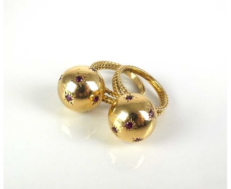 A pair of ruby set orb rings, each designed as a yellow metal polished orb set with eight round faceted rubies and mounted to