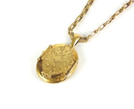 A Victorian yellow metal oval locket suspended from gold decorative link chain, the oval locket with bright cut engraved deco