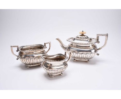 A late Victorian three piece silver tea service, William M Hayes, Birmingham 1899, each piece of oval half reeded form and ra