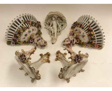 A pair of Continental porcelain wall shelves, supported by putti and flowers, with a pair of Capo di Monte wall shelves, putt