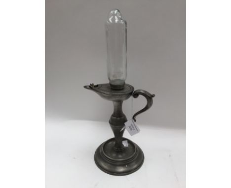 A whale oil lamp clock, the base in pewter, original glass oil reservoir but markings now worn off, imprint to top 