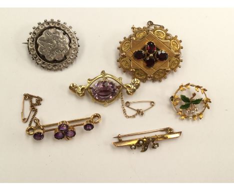 Two amethyst set brooches, a Victorian target brooch set garnets and a wreath brooch with green enamel set three diamonds, et