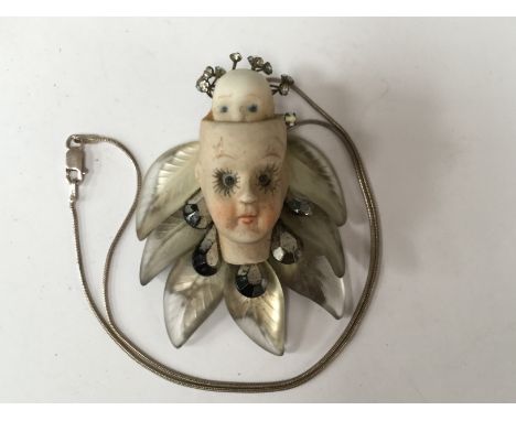 A vintage Wendy Gell pendant featuring a lady made from ceramic and mother of pearl and a 1956 sixpence 