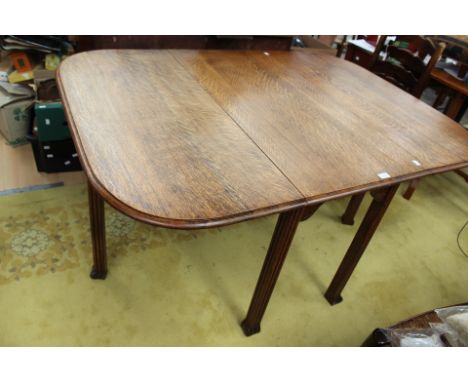 An early 20th Century oak gateleg table, together with a pair of ladder back chairs, with rush seated chairs