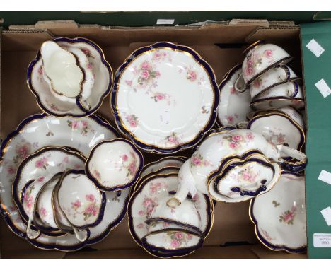 A large George Jones tea service, enamelled rose with dark blue edging to scalloped service, with setting for twelve includin