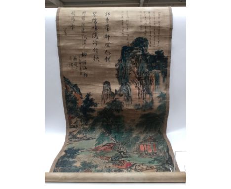 A mid 20th Century Chinese scroll canvas of a colourful mountain scene with a man on horseback on route to a small pegoda bea