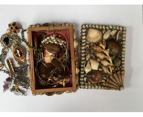 A collection of costume jewellery together with vintage brooches and silver necklace, all located within a shell box