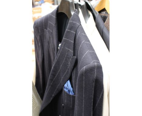 A navy aquascutum man's shirt in light weight wool with a summer beige jacket, a cream men's light weight suit with tie, a pi