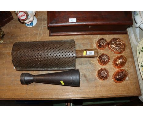 A vintage metal sifter, a large vintage grater and six copper moulds