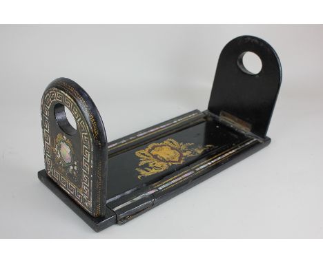 A Victorian papier mache book stand, black lacquered with mother of pearl and gilt decoration, 34cm, (a/f)