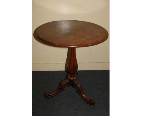 A Victorian burr walnut circular side table, with tilt top on fluted baluster stem and tripod base with foliate carved scroll