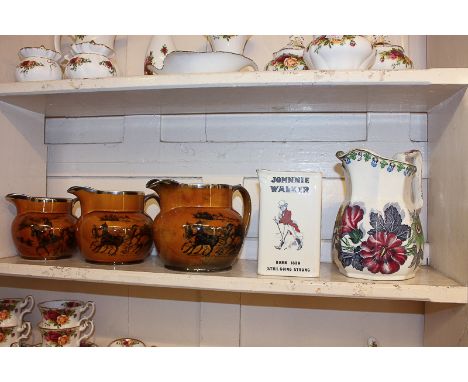 A set of three graduated jugs with printed designs of 'Old English Coaching Days', a Johnnie Walker whisky water jug (a/f), a