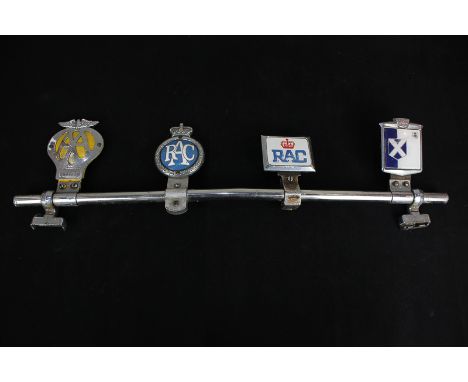 Two Royal Automobile Association car badges, an Automobile Association badge, and another with Scottish flag, mounted on a ch