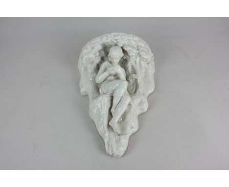 A 19th century porcelain wall bracket, modelled as a seated female figure holding a bowl under a canopy of trees, 23cm