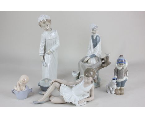 Two Lladro porcelain figures of a child with polar bear and a woman seated on a branch (second) together with three Nao porce