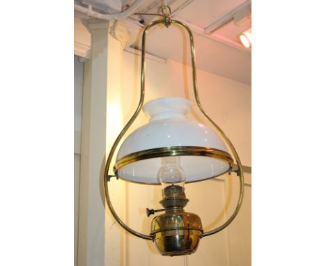 A brass hanging oil lamp, marked English Juno, with clear glass funnel and white shade, 80cm
