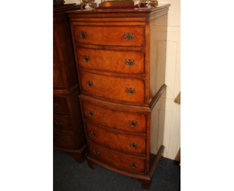 A reproduction bowfront walnut tallboy, with three over three drawers, on bracket feet