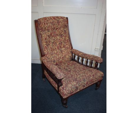 A William Morris style upholstered armchair with button upholstered back, padded arms on balustrade supports, on spiral flute