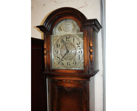 A 20th century longcase clock with silvered dial and chiming movement, in panelled oak case, on bun feet, 194cm high