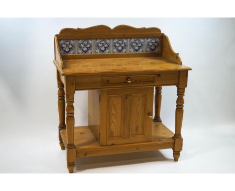 A Victorian tile back pine wash stand, the base fitted with a single drawer above a cupboard and lower shelf