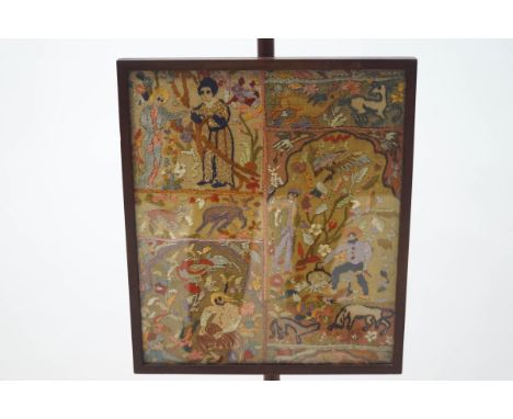 A 19th century mahogany firescreen with embroidered panel depicting figures and animals in the countryside, on turned column 