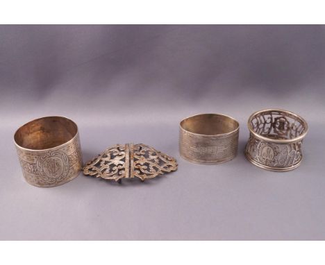 Three silver napkin rings, one with engine turned decoration, another pierced and another with engraved decoration, all with 