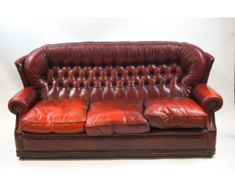 A red leather button back three seat sofa 187cm wide x 85cm deep