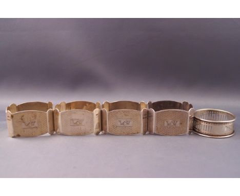 A set of four silver engine turned oblong napkin rings, Birmingham 1932; and another pierced round example, 1935, 113g gross 