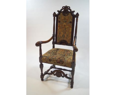 A 19th century beech and mahogany armchair with carved scroll and shell crest rail, scroll arms, and turned and block support